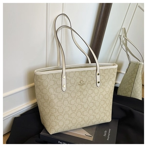 Detail of premium beige tote bag with chic ring pattern and elegant gold hardware