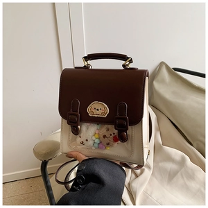 Detail of college style cream and brown backpack with transparent PVC window and plush toys