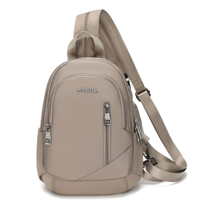 Détail du tissu en nylon taupe imperméable et du logo métallique sur le sac bandoulière