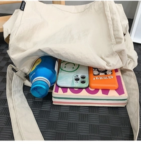 Détail montrant l'intérieur spacieux de ce sac fourre-tout avec des livres et bouteille