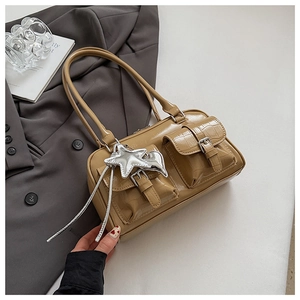 Detail der khakifarbenen Krokodilleder-Handtasche mit Taschen und silbernen Sternanhängern