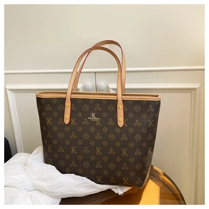 Detailed close-up of dark brown tote bag with classic floral monogram and dual handles