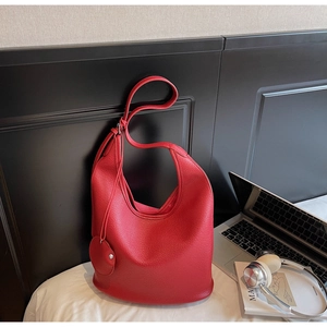 Detailed macro view of red lychee grain leather hobo bag with matching leather bag charm