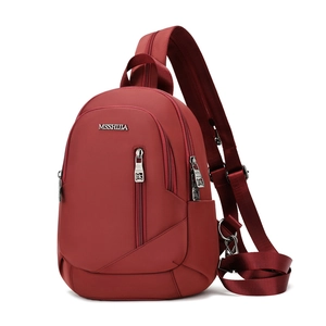Vue avant du sac bandoulière en nylon rouge foncé avec compartiments et logo métal