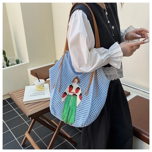 Detail of light blue knit tote bag with cartoon girl embroidery and brown leather straps