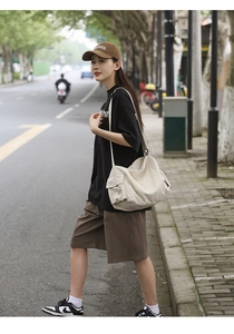 Gros plan d'un sac cabas en toile crème avec plusieurs poches dans un look street style