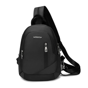 Gros plan du sac bandoulière en nylon noir avec logo métallique et compartiments zippés