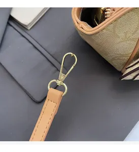 Detail der champagnerfarbenen Logo-Handtasche mit goldenen Beschlägen und Lederriemen