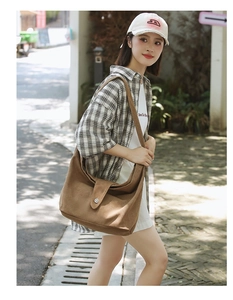 Detail of caramel canvas crescent bag with magnetic flap closure and soft brushed texture