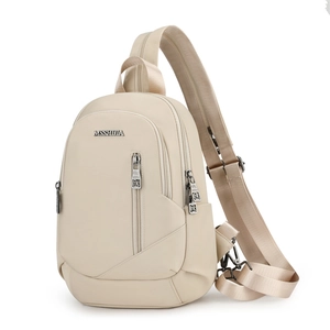 Détail du sac bandoulière en nylon beige avec logo en métal et fermetures éclair