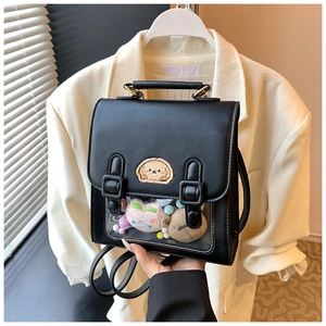 Detail view of a black PU backpack with a transparent window filled with plush toys