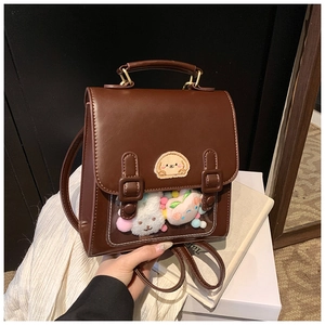 Detail of vintage brown leather mini backpack with transparent window and puppy embroidery