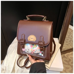 Detailed view of brown leather ita-bag with clear PVC window and plush charm interior