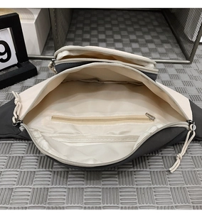 Detail view of the spacious inner compartments and zip pocket of this fabric crossbody bag
