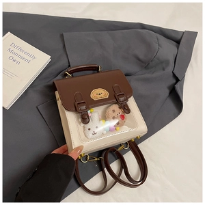 Detail view of two-tone collegiate backpack with transparent window and plush charms