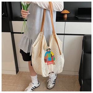 Close-up of beige knit tote bag with colorful cartoon girl embroidery and brown leather strap