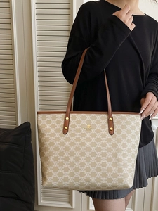 Classic patterned tote bag with brown leather straps shown on a model against blinds