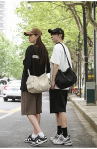 Photo de rue de grands sacs bandoulière en toile en beige et noir pour usage quotidien