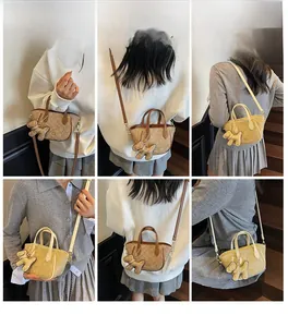 Detailansicht der Umhängetaschen mit Monogrammmuster und niedlichen Hundeanhängern