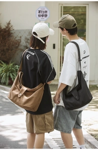 Detailed view of khaki and black canvas crossbody bags shown from a back perspective