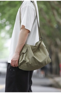Vue latérale du sac fourre-tout en nylon vert olive avec poche et détail d'étiquette