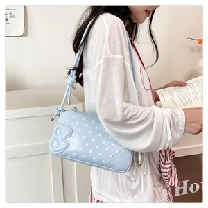 Detail of light blue polka dot shoulder bag with B logo and knotted strap detail