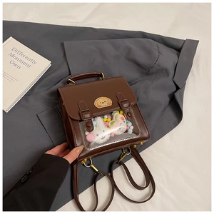 Close-up of retro brown leather backpack featuring a transparent window with cute plush toys
