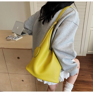 Detail of yellow lychee grain leather tote bag showing texture and adjustable strap