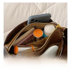 Macro shot of brown Boston bag interior showing spacious capacity for cosmetics and phone