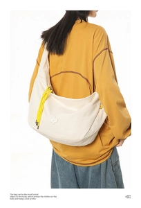 Macro detail of creamy crossbody bag with textured checkered fabric and yellow drawstrings
