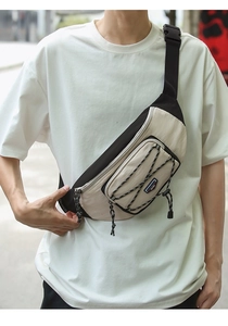 Detail of street style crossbody chest bag with adjustable strap and drawstring pocket