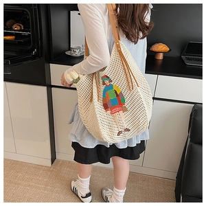 Detail of knit tote bag with colorful girl embroidery and brown faux leather strap