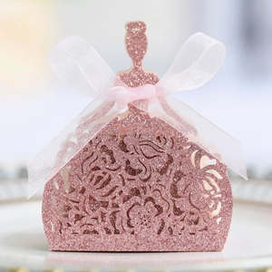 Détail des motifs de roses découpés au laser et paillettes roses sur la boîte cadeau robe