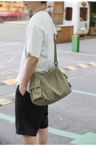 Détail de la sacoche en nylon vert olive montrant la poche latérale et l'étiquette tissée