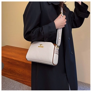 Detail of white leather crossbody bag featuring gold kangaroo logo and wide printed strap