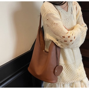 Detail shot of brown lychee grain leather texture on a high-quality tote shoulder bag