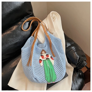 Detail of light blue crochet tote bag with cartoon girl embroidery and brown leather strap