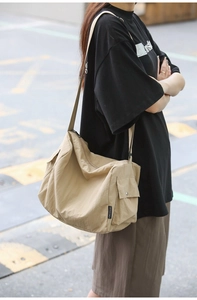 Photo extérieure d'un grand sac bandoulière beige avec bandoulière réglable en tissu