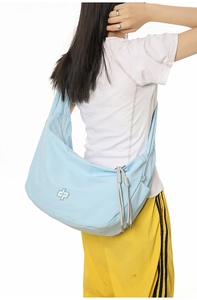 Detail of light blue checkered hobo bag showing the plaid fabric and white logo detail