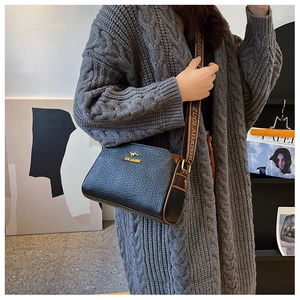 Detail of woven texture Boston bag with kangaroo logo and wide fabric shoulder strap