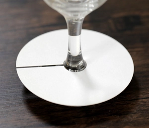 Gros plan de marque-places ronds blancs pour verres à vin sur table bois