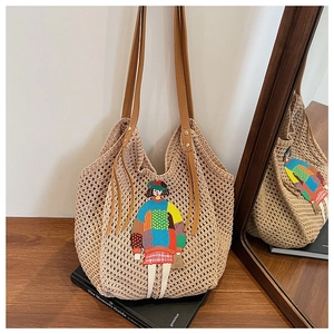 Detail of knit tote bag with cartoon patchwork embroidery and brown faux leather straps