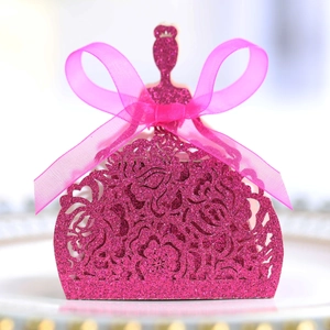 Détail de la boîte cadeau rose pailletée en forme de robe avec motifs découpés au laser