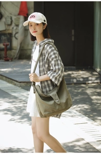 Detail of army green canvas crossbody bag showing spacious capacity and adjustable strap
