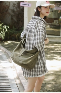 Detail of army green canvas crossbody bag with wide shoulder strap and soft hobo structure