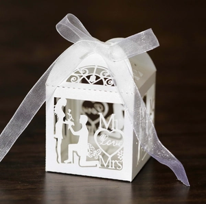 Detailed laser-cut wedding favor box with heart silhouettes and white ribbon bow
