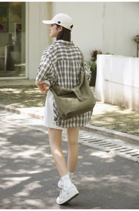 Olive green canvas crossbody bag featuring large capacity and stylish flap closure design