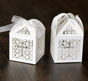Macro view of white laser-cut gift box with hollow cross patterns and ribbon detail