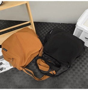 Détail de grands sacs messagers en caramel et noir avec large bandoulière réglable