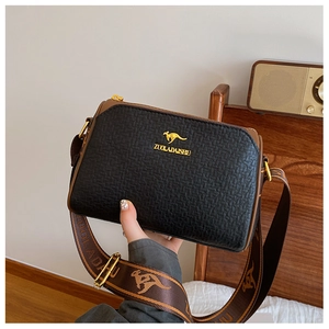 Detail of black pebbled leather Boston bag with vintage jacquard strap and gold kangaroo logo